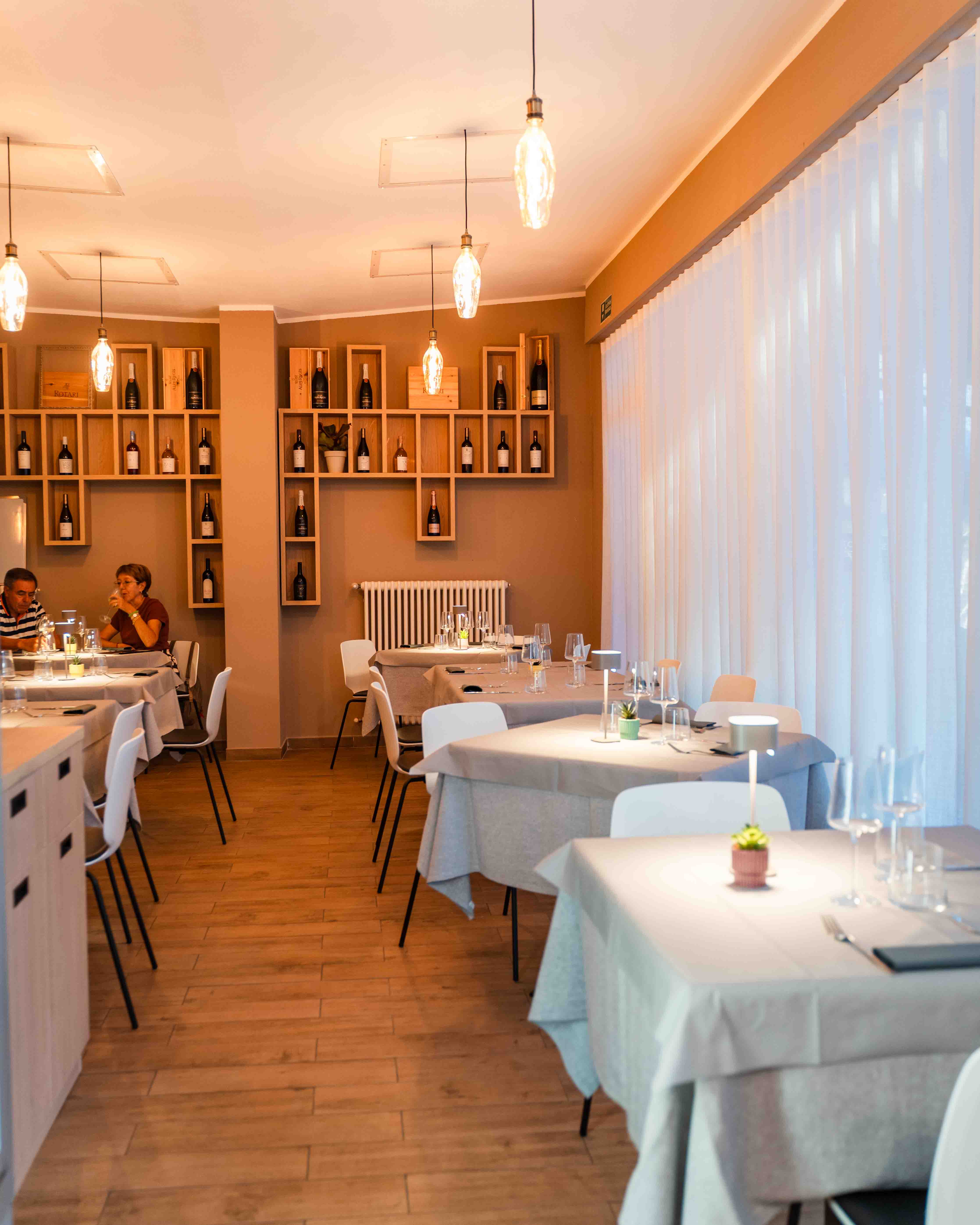 Sala del ristorante apparecchiata con luce calda